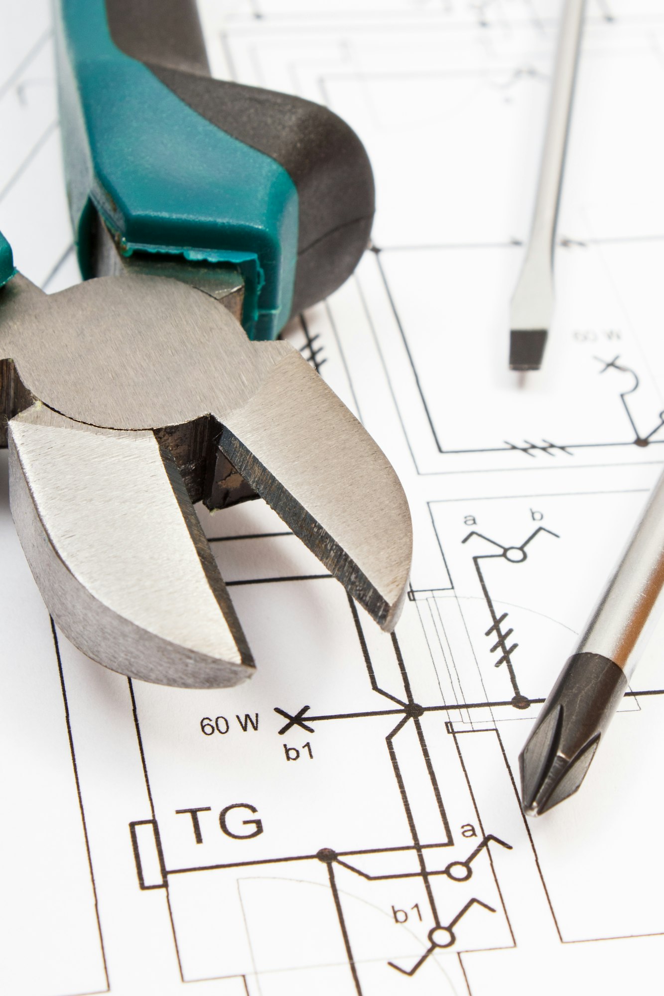 Metal pliers and screwdriver with electrical diagrams of house. Building home